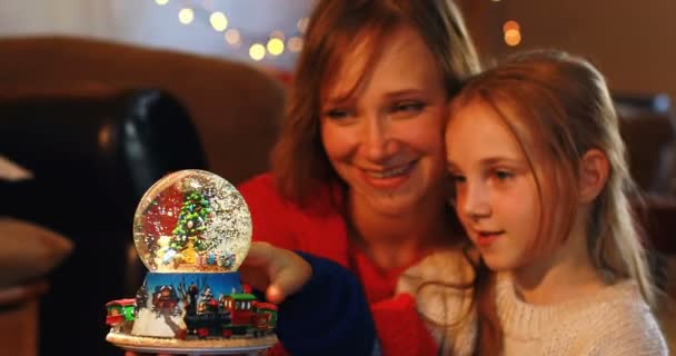 Mother and daughter playing with crystal ball toy during Christmas at home  - Video, Çekim