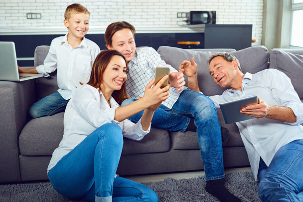 A happy family with a laptop is having fun in the room - Foto, Imagen