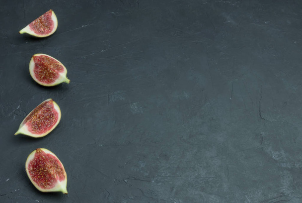 Fresh figs. Food photography. Creative scheme of whole and sliced figs on a dark background, inscribed in a rectangle. Copy space - Photo, Image