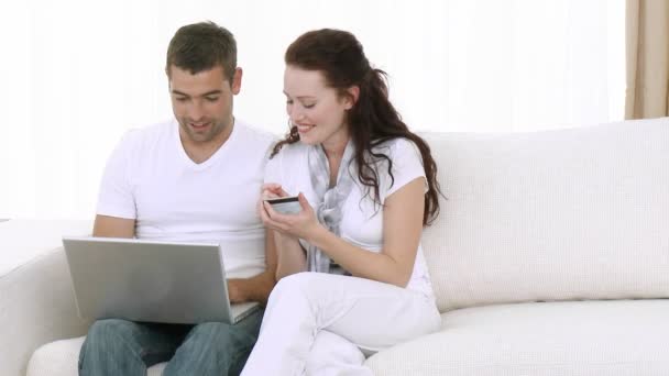 Young Couple at home using a laptop - Кадры, видео