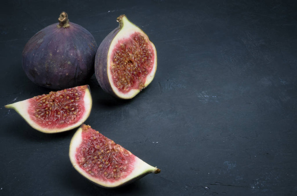 Fresh figs. Food photography. Creative scheme of whole and sliced figs on a dark background, inscribed in a rectangle. Copy space - Fotoğraf, Görsel