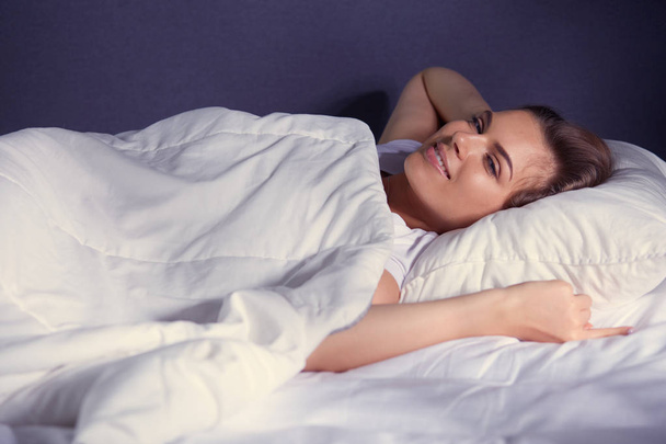 mooie jonge blonde vrouw slapen in bed - Foto, afbeelding