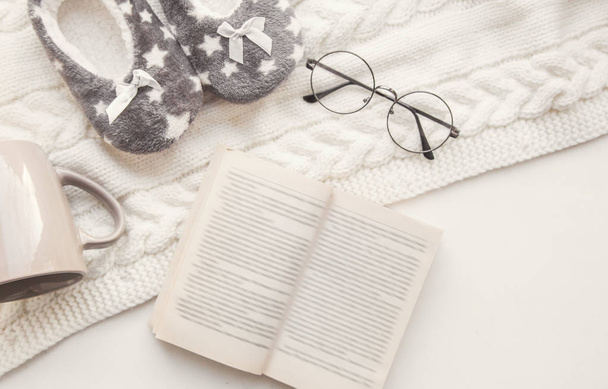 home comfort and winter evening. soft focus vintage glasses, book. top view of home slippers, a mug on a knitted rug flatlay. learning, profession editor, proofreader, writer - Valokuva, kuva