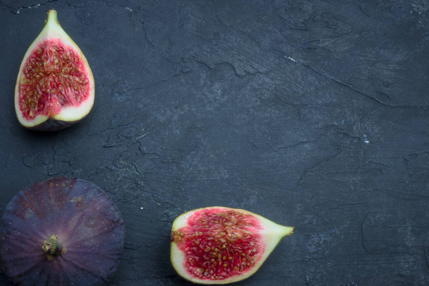 Fresh figs. Food photography. Creative scheme of whole and sliced figs on a dark background, inscribed in a rectangle. Copy space - Foto, Imagen
