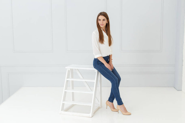Fashion portrait of woman in jeans in light studio background - Φωτογραφία, εικόνα