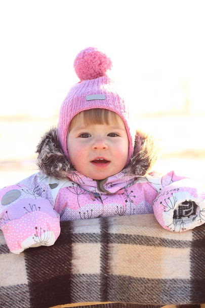 child outside on the field in winter in warm clothes - Foto, Imagen