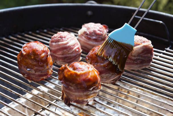 Cuisson et vitrage des boulettes de viande recouvertes de bacon
 - Photo, image