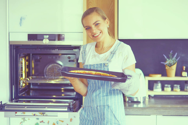Happy young woman cooking pizza at home - Valokuva, kuva