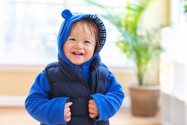 Happy toddler boy bundled up in winter clothes - Fotó, kép