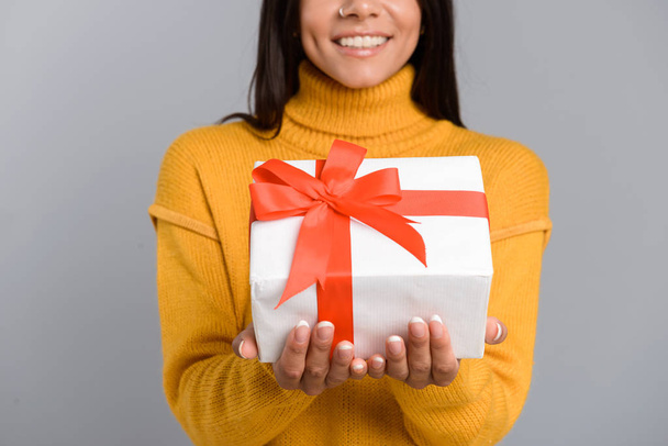 Cropped photo of cheerful woman posing isolated over grey wall background holding box surprise present. - Φωτογραφία, εικόνα