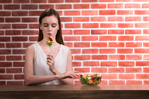 schöne junge Frau in freudiger Haltung mit Salat in der Hand  - Foto, Bild