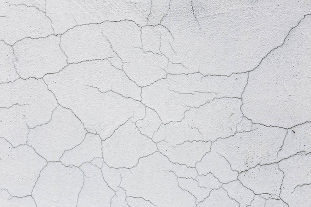 Υφή του λευκό βρώμικο τοίχο ραγισμένα. Μικρές ρωγμές ευθεία. Άμεση κάταγμα βαμμένη επιφάνεια. Κύτταρα σχισμή - Φωτογραφία, εικόνα