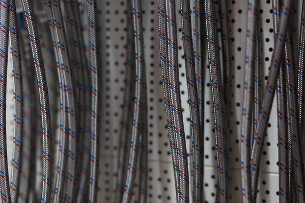 Texture tressée en acier inoxydable du tuyau flexible disposé en rangée au magasin de matériaux de construction
 - Photo, image