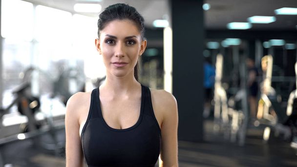 Portrait of confident young woman in gym looking into camera, personal trainer - Foto, immagini