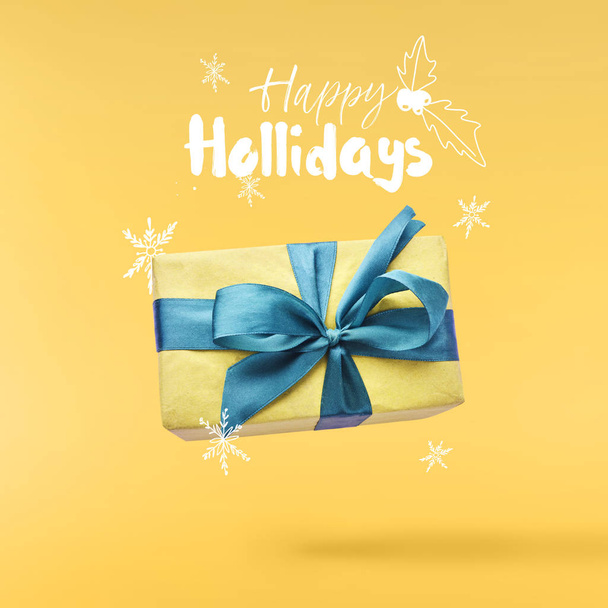 Christmas concept.  Creative Christmas conception made by falling in air gift box over yellow background. Minimal concept - Foto, immagini