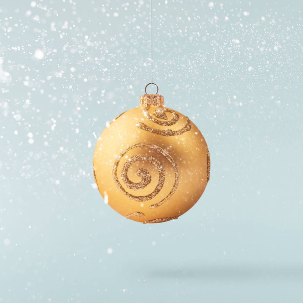 Рождественская идея. Творческая рождественская концепция, выполненная путем падения в воздухе сверкающего золотом бокала над синим фоном. Минимальная концепция
 - Фото, изображение