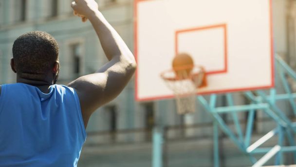 Professional basketball player throwing ball into basket, active training - Foto, Bild