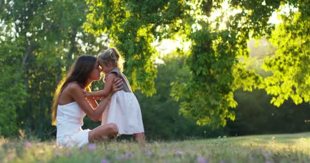 ecologie, jonge moeder met haar schattige twee jaar oud meisje buiten spelen met liefde. concept van de familie liefde voor de natuur. gelukkige kinderen met de liefde van ouders. concept van groen en duurzaamheid. - Video