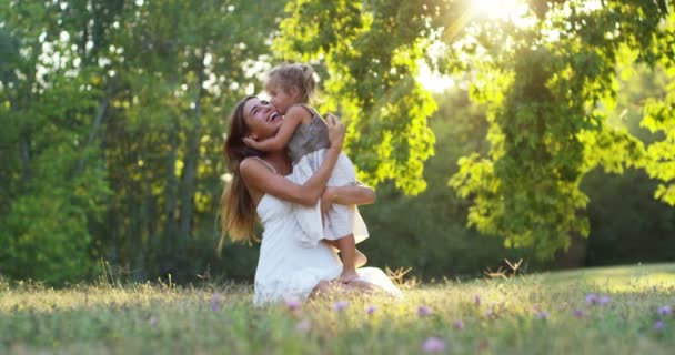 ekologie, mladá matka s její rozkošný dva let stará dívka hraje venku s láskou. koncepce rodinné lásky k přírodě. šťastné děti s láskou rodiče. koncept zelené a udržitelnost. - Záběry, video