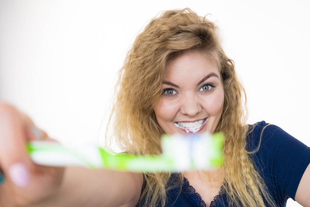 Woman brushing cleaning teeth. Positive girl with toothbrush. Oral hygiene. Studio shot on white background - Foto, immagini