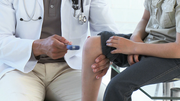 Close-up of doctor checking little patient's reflexes - Filmmaterial, Video