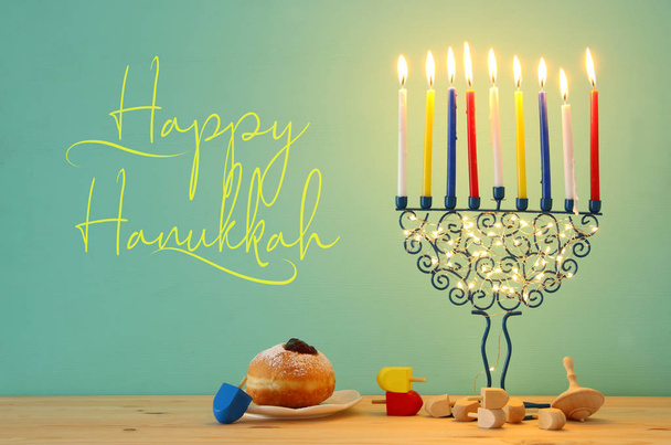 image of jewish holiday Hanukkah background with menorah (traditional candelabra) and colorful candles - 写真・画像