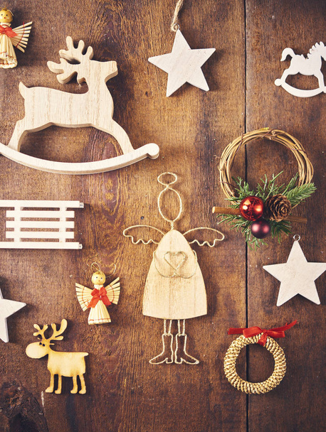 Christmas background. Set with a lot of different wooden baubles and  toys over dark wooden board. Christmas ecologic concept - Photo, Image