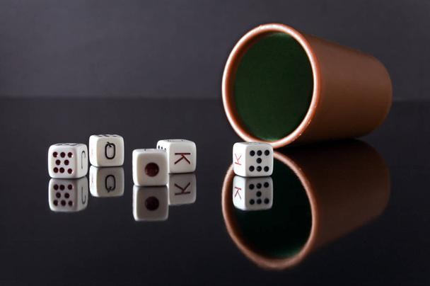 Dados de poker y cubilete sobre fondo negro - Photo, Image