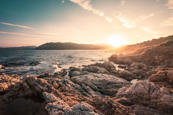 Auringonnousu kallioisella rannikolla Lozarissa Balagnen alueella Korsikalla
 - Valokuva, kuva
