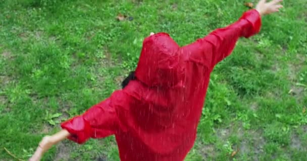 slow motion video woman wearing red coat and spinning around under rain, top view - Séquence, vidéo