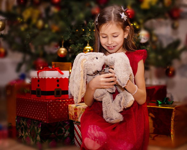 Ευτυχισμένη κοριτσάκι χαμογελά με Χριστουγεννιάτικο δώρο - Φωτογραφία, εικόνα