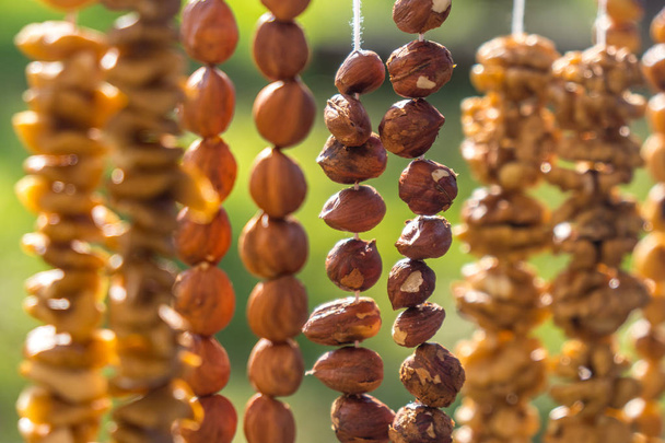 Půlky vlašských ořechů na dlouhé vlákno - Příprava prázdné pro výrobu churchkhela sladký dezert domácí cukroví - tradiční Gruzínské jídlo s hroznovou šťávu, ořechy a kukuřice nebo bílé mouky. - Fotografie, Obrázek