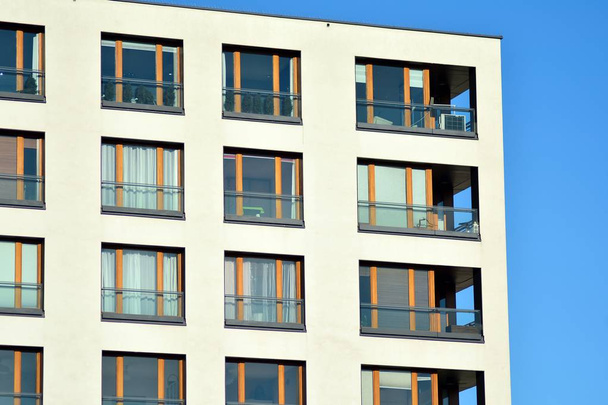 Fragment d'une façade d'un bâtiment avec fenêtres et balcons. Maison moderne avec de nombreux appartements
. - Photo, image