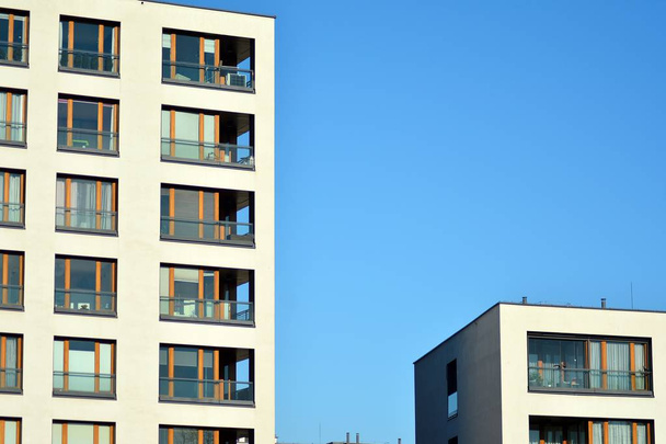 Fragment einer Fassade eines Gebäudes mit Fenstern und Balkonen. Modernes Eigenheim mit vielen Wohnungen. - Foto, Bild
