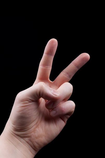 Mano con signo de paz sobre fondo negro
 - Foto, Imagen