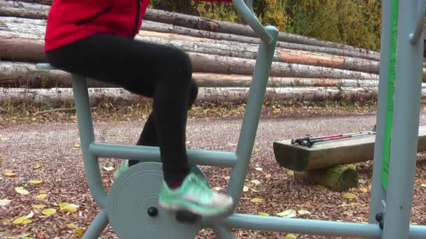 Cycling trainer in the autumn forest. The girl trains in the fresh air. - Footage, Video
