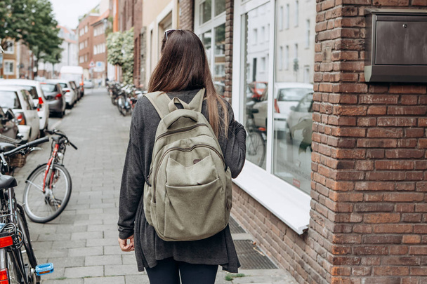 Turista con una mochila está buscando alojamiento en línea reservado en una ciudad desconocida
. - Foto, imagen