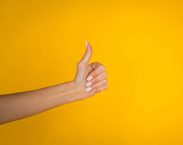 Woman hands over yellow background with copyspace - Photo, Image