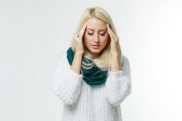 Sickness cute young blonde woman wrapped scarf having headache, touching her temple and closed eyes, closeup. Cold, virus, migraine, flu season concept. - Foto, afbeelding