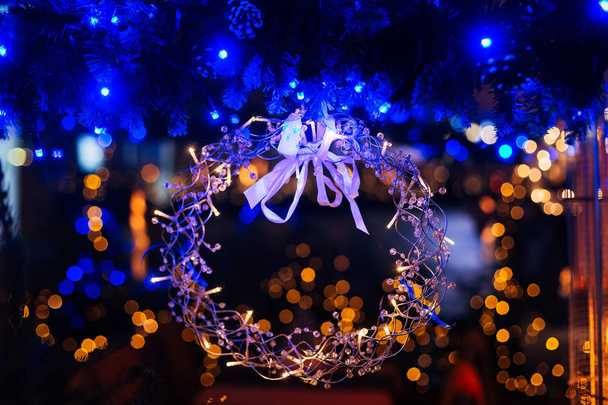 ramos de um abeto com grinaldas de luzes azuis e um close-up de uma grinalda de Natal de arames metálicos
 - Foto, Imagem