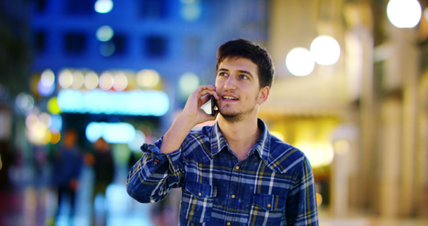 Şehirde bir gece bak dostum. Milan İtalya yakışıklı genç iş adamı telefon mavi gömlek giymiş mutlu gülümseyerek kullanarak. Kentsel erkek. - Video, Çekim
