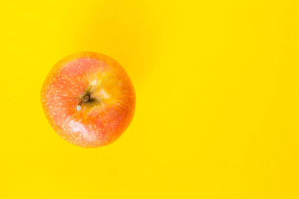 red apple top focus on yellow background - Fotografie, Obrázek