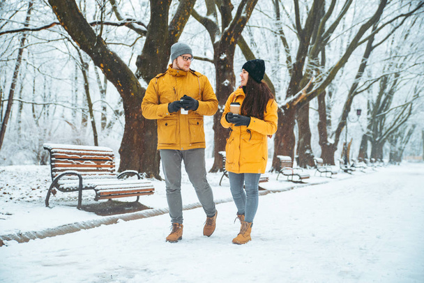 пара, гуляющая по снежному городскому парку и общающаяся. романтическое свидание зимой. Рождество грядет
 - Фото, изображение