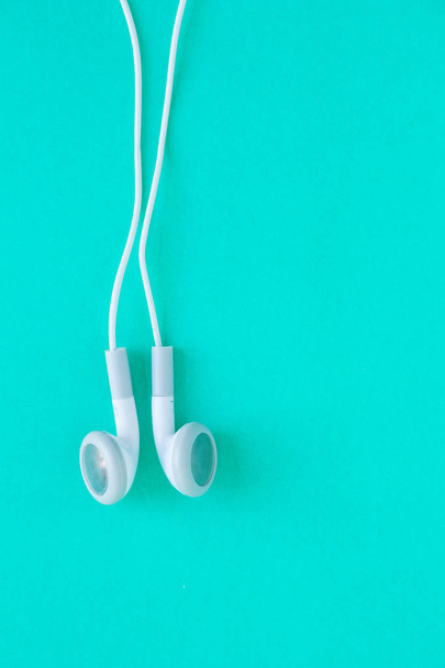 earbuds or earphones on green background - Foto, Imagen