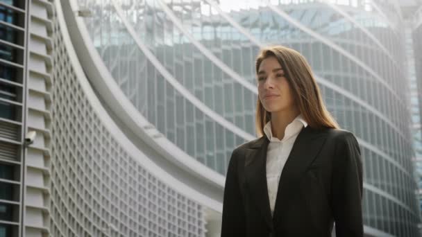 Slow-motion video van vrouw zaakvoerder buitenshuis op moderne kantoor glazen gebouw wijzen met de vinger op onzichtbaar virtuele holografische  - Video
