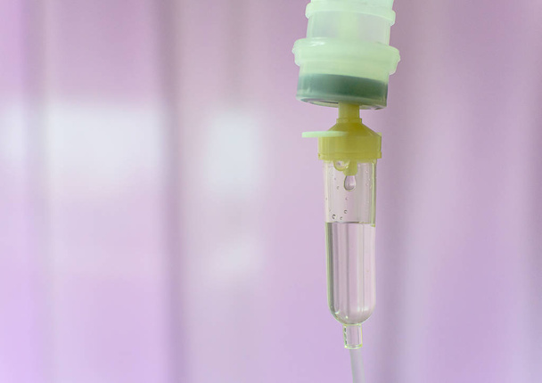 Закрыть капельницу физраствора IV для пациента и инфузионный насос в больнице с фиолетовым фоном
.. - Фото, изображение