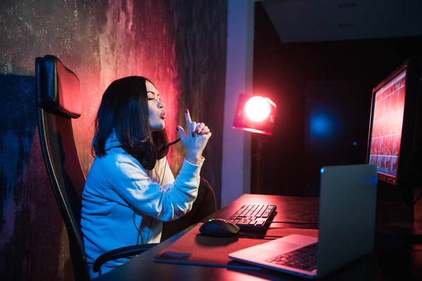 jonge aantrekkelijke tiener vrouw brillen op zoek donkere en gevaarlijke hacken computersysteem op zwarte achtergrond in cybercriminaliteit of cyber misdaad en internet criminele concept - Foto, afbeelding