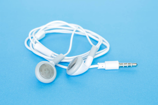 earbuds or earphones on blue background - Photo, Image