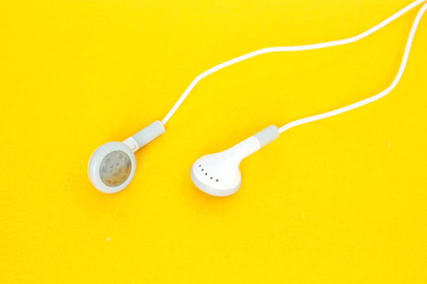 earbuds or earphones on yellow background - Photo, Image