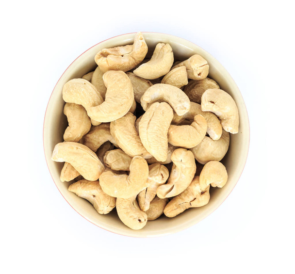 cashew in white bowl top view on white background. - 写真・画像